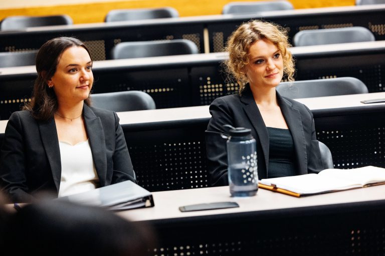 Two women sitting behind a table in a courtroom