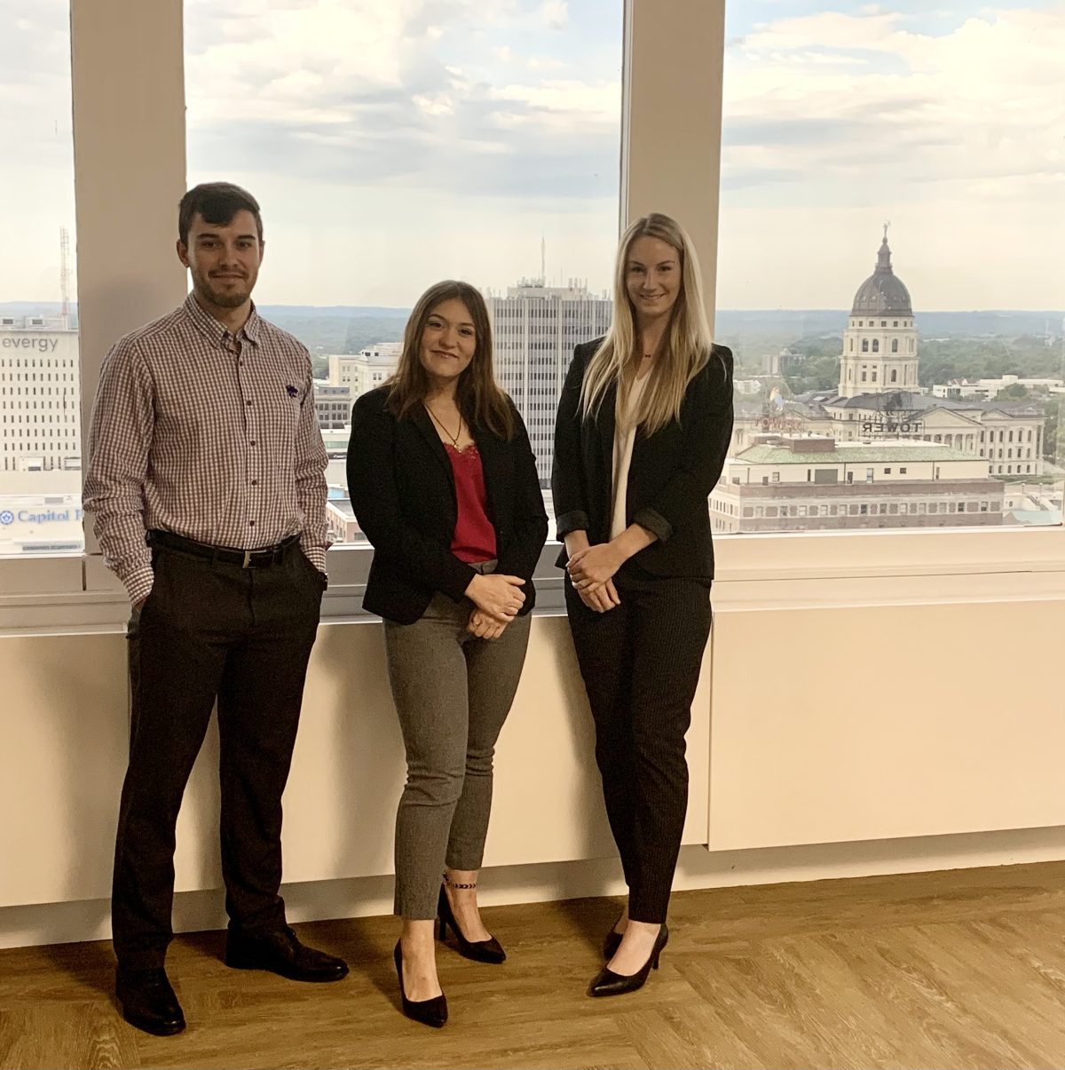 Arielle Jacobs and colleagues in front of window overlooking city skyline