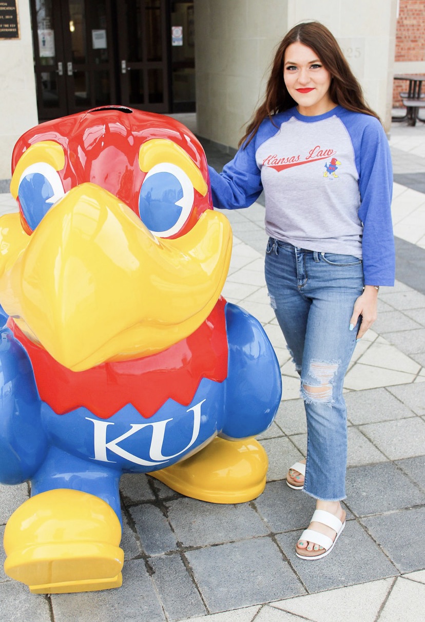 Arielle Jacobs casually dressed posing with Jayhawk statue in front of the Kansas Union