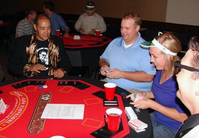 Group of 4 students playing cards at Casino Night fundraiser
