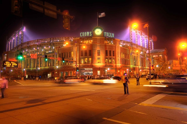 Nighttime view of a historic building or theater with colorful lights illuminating the facade.