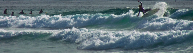 A distant view of a surfer or person on a wave in the ocean.