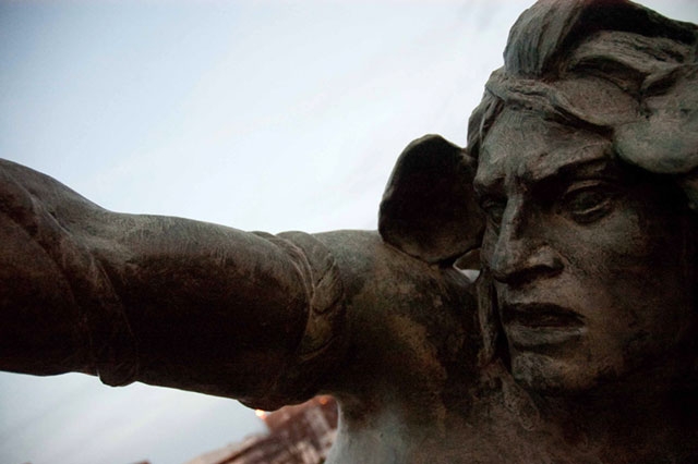 A close-up of what appears to be a stone sculpture or statue showing a human face.