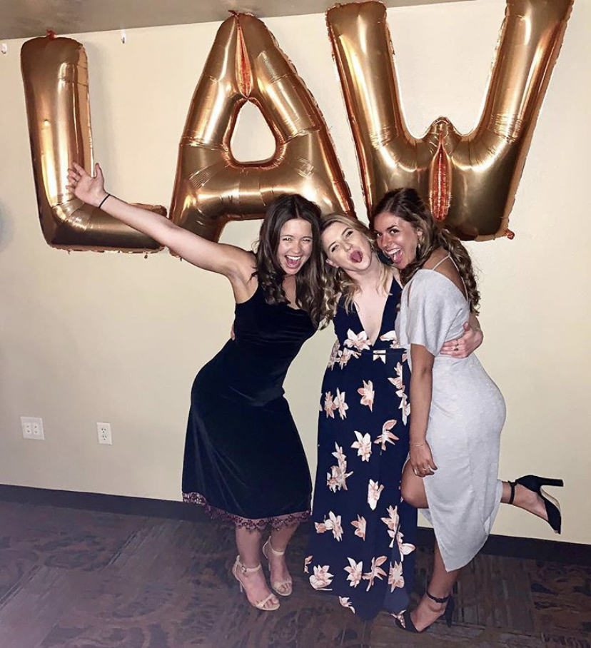 Law students Anna Meyer, Cori Moffett and Becca Henderson pose in front of balloons shaped like the letters of the word LAW