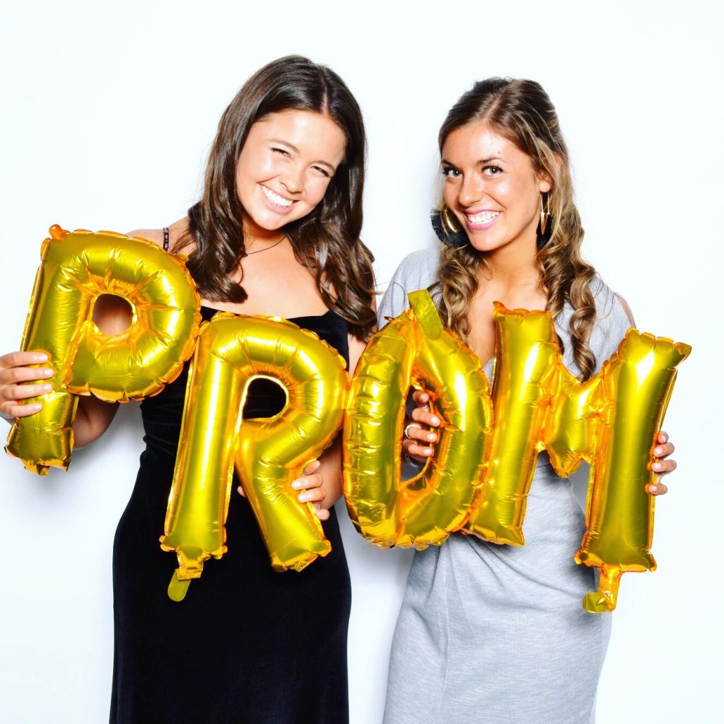 Law students Anna Meyer and Becca Henderson hold up balloons spelling the word PROM