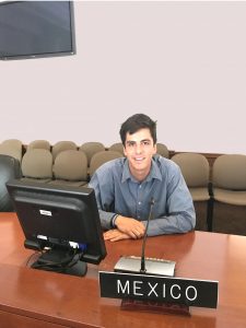 Arturo Garcia sitting at a table with a sign that reads 'Mexico'