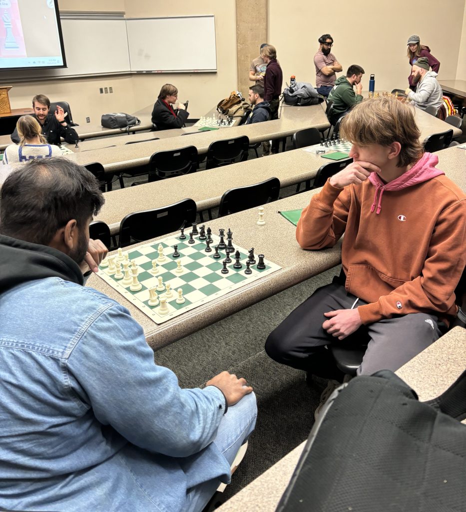 People gathered around various chess games for meeting of the chess club