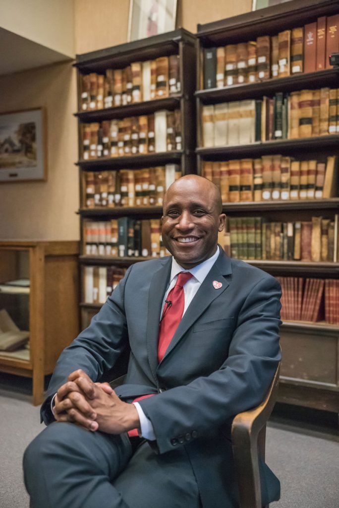 Quinton Lucas sitting in a library posing in a chair.