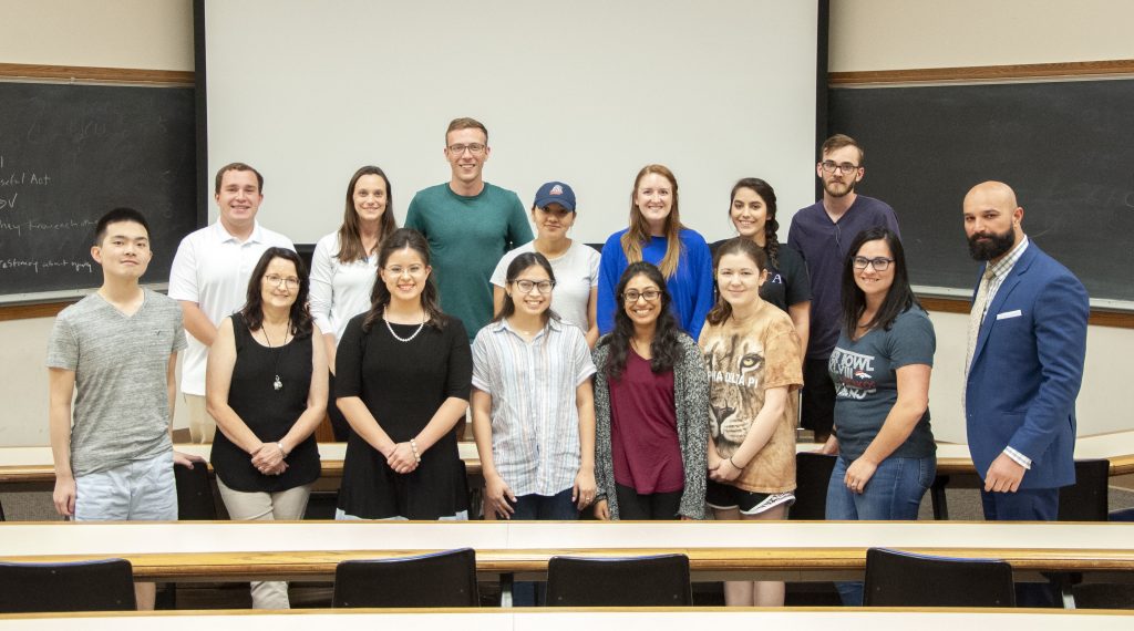 All members of the First Generation Professionals organization standing together in a classroom.