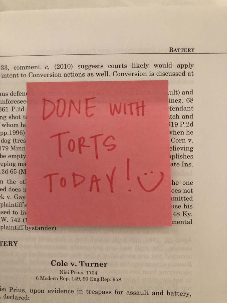 Encouraging sticky note inside a book says "Done with Torts Today!"