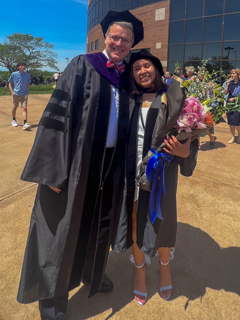 Paula Lopez with Professor Lou Mulligan in graduation regalia