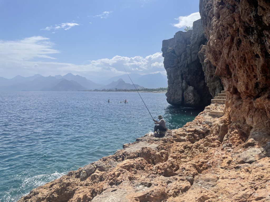 Fisherman fishing by the coast
