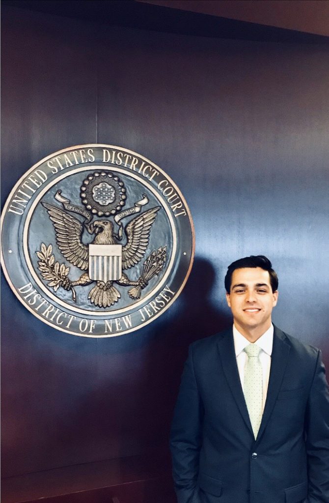 Jacob Elberg in front of a seal for the United States District Court