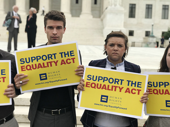 James Hampton holding a sign that reads 'support the equality act' 
