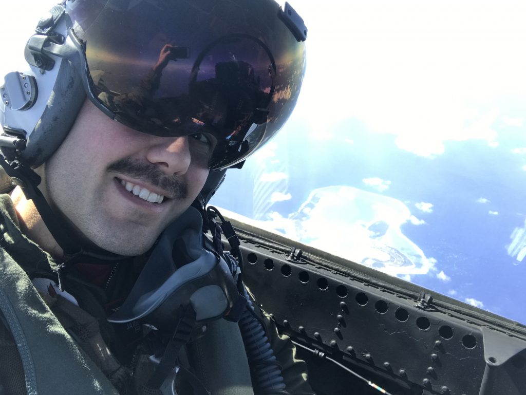 Jared Jevons taking a selfie in a plane over an island.