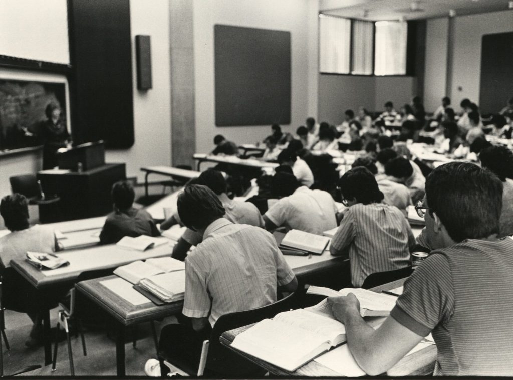 Ellen Sward at the front of a classroom with students listening to her lecture