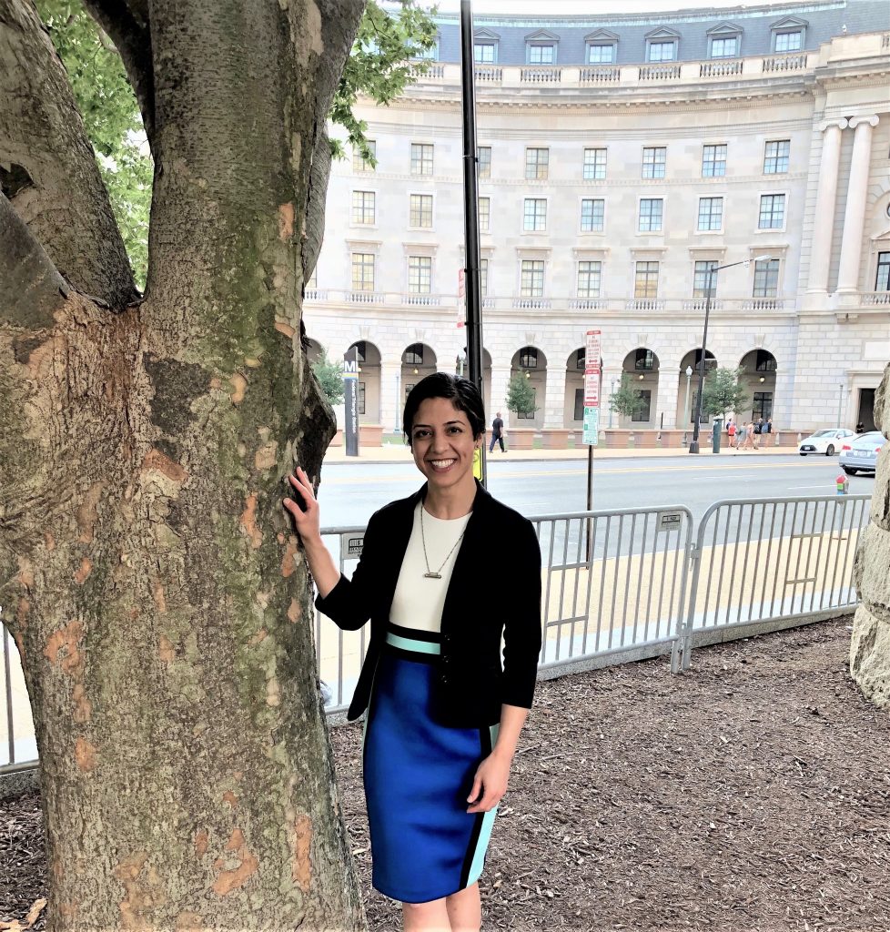 Ava Azad posing next to a tree.