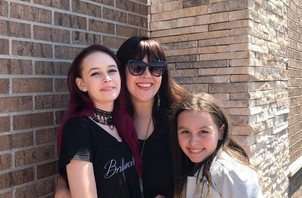 Kendra Stacey with one daughter on each side of her
