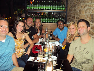 a group of people smiling for the camera around a table