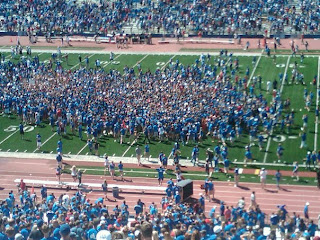 Group of fans on the field of Booth memorial stadium field as viewed from the stands
