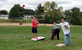 A group of men playing cornhole