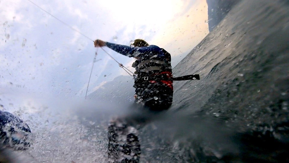 Person in water suspended from catamaran.