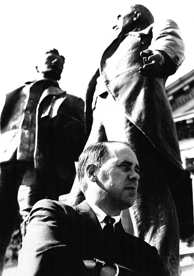 Former KU Law Dean James Logan sitting on base of Green Memorial statue in 1968