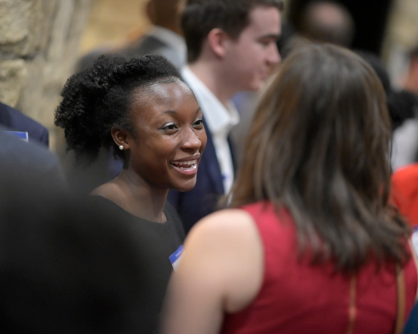 Denise Dantzler dressed professionally talking to someone in a crowd.