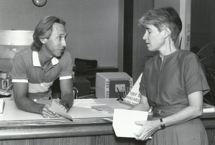 KU Law Professors Webb Hecker and Elinor Schroeder converse in the front office of Green Hall