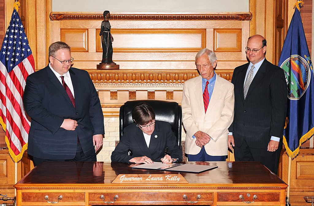 Gov. Laura Kelly signs House Bill 2039. Pictured from left: William Quick, Gov. Laura Kelly, Webb Hecker, William Matthews