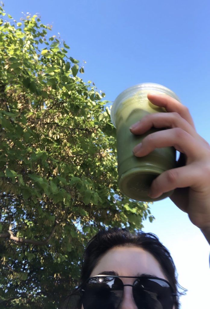 Savannah Lucas holding up an iced matcha