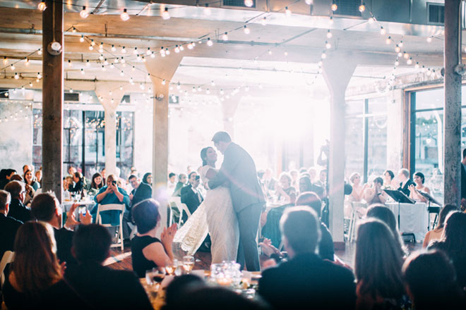 Sangeeta Shastry dancing at her wedding surrounded by family and friends at tables.