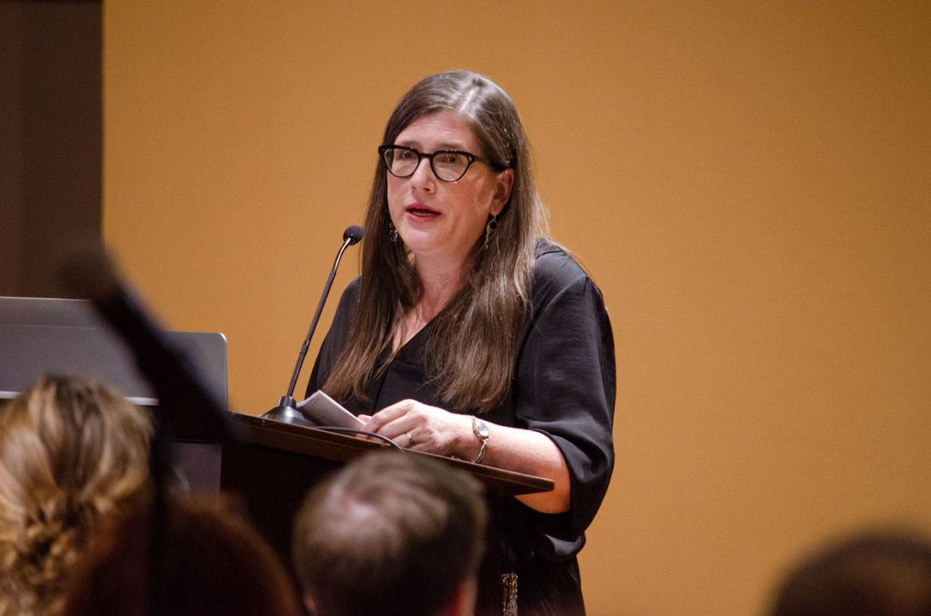 Sarah Deer presenting at a podium.